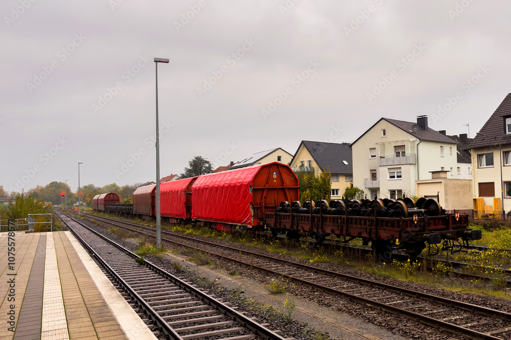 Train cars parked alongside residential buildings on a cloudy day Train cars parked alongside residential buildings on a cloudy day