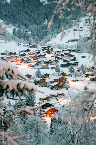 Grindelwald, under the soft glow of the night lights, transforms into a magical village where the snow glistens and each chalet seems to watch over the peaceful, slumbering mountains, Switzerland.