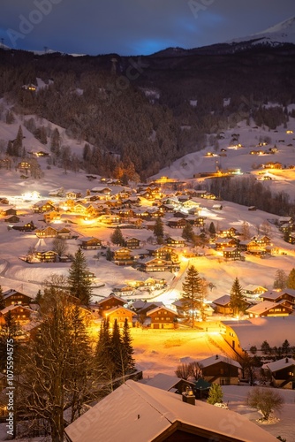 Grindelwald, under the soft glow of the night lights, transforms into a magical village where the snow glistens and each chalet seems to watch over the peaceful, slumbering mountains, Switzerland.