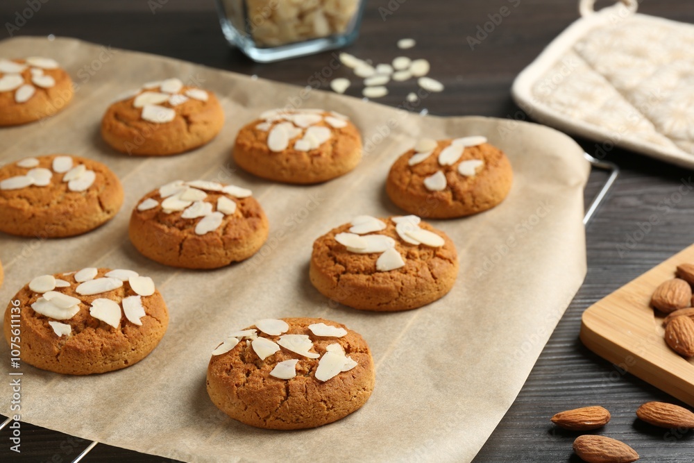 Tasty cookies with almond flakes and nuts on wooden table, closeup Tasty cookies with almond flakes and nuts on wooden table, closeup