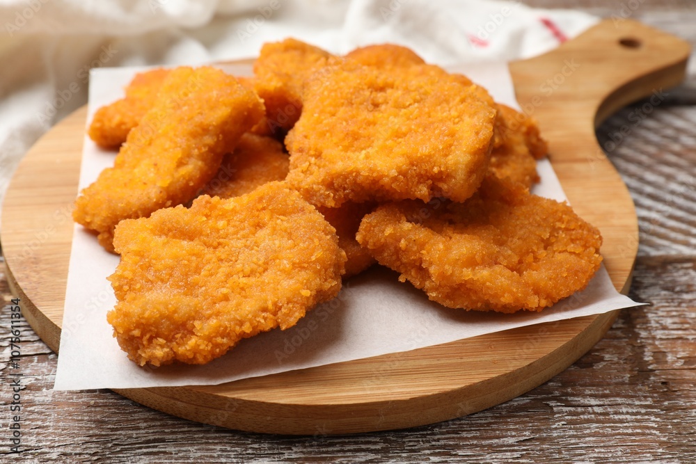 Delicious chicken nuggets on wooden table, closeup Delicious chicken nuggets on wooden table, closeup