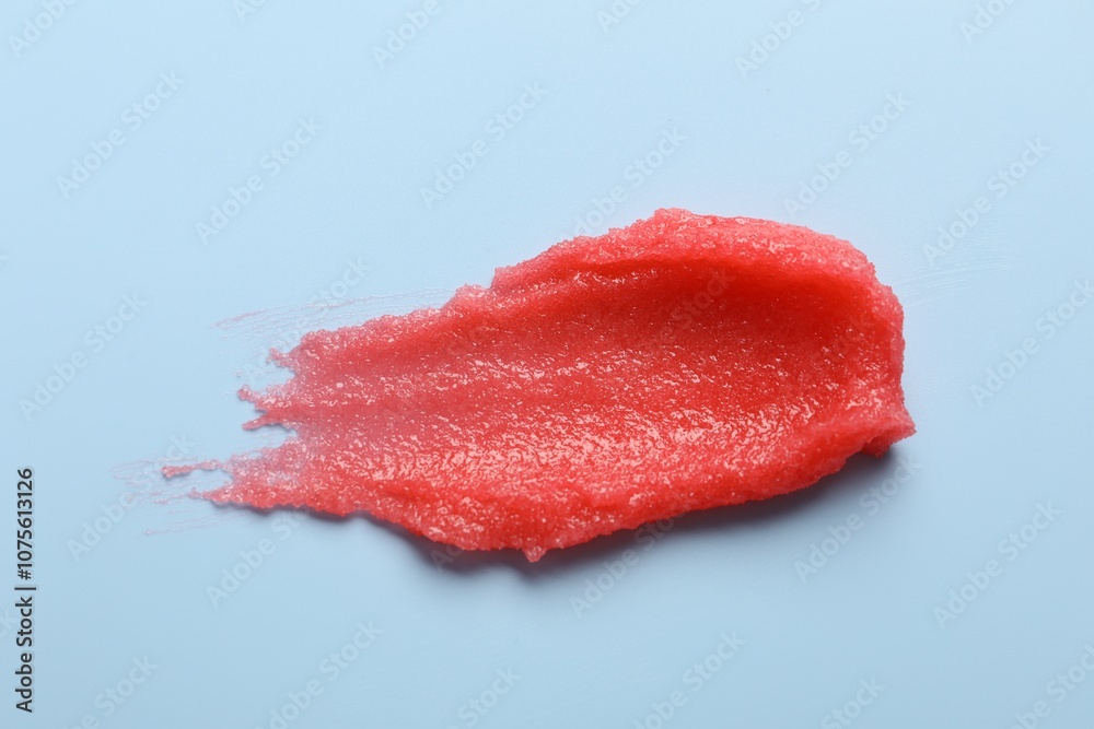 Smear of body scrub on light blue background, top view