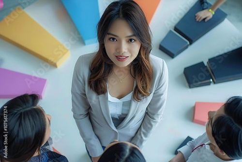 Full body photo of Asian woman connecting with colleagues in a circle at the office, standing with pie chart segments photo