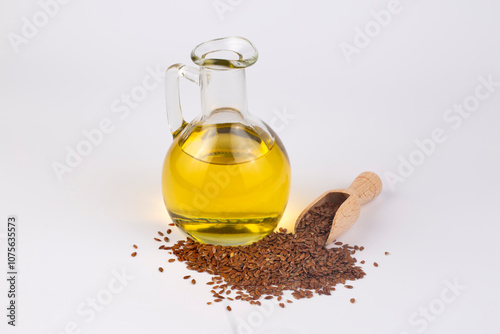 Flaxseed oil and pile of organic flax seed isolated on white background