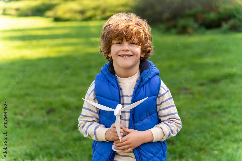 Naklejka premium Kid boy exploring wind turbine model in protecting environment