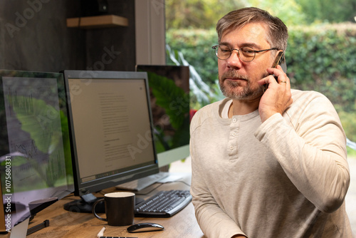 employé de bureau ou cadre d'entreprise de 50 ans en télétravail qui est en train de téléphoner photo