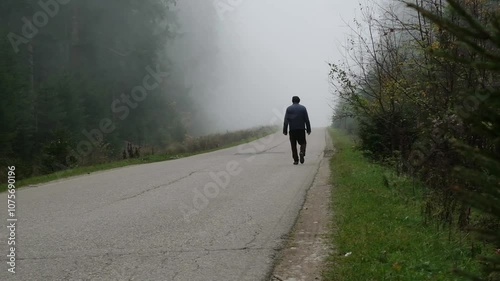 Man walking on road forest mist and fog
