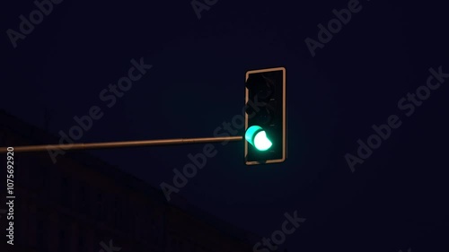 A traffic light changes from red to green at night.