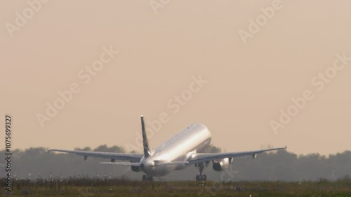 Footage of a plane accelerating and taking off in backlight. Aircraft departure. Jet plane fly away