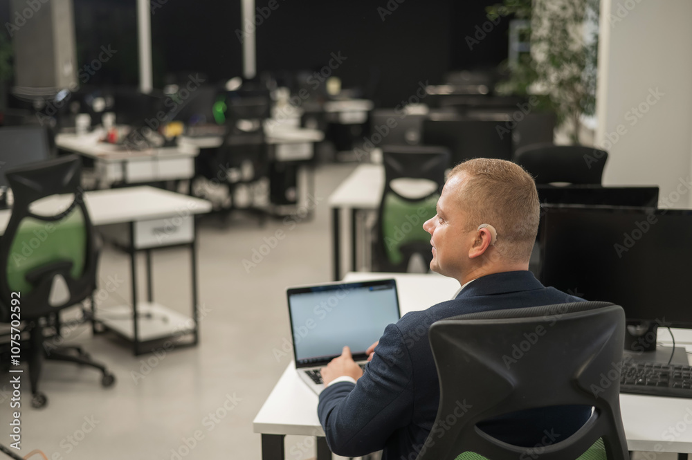 Caucasian deaf man typing on laptop in office. Caucasian deaf man typing on laptop in office.