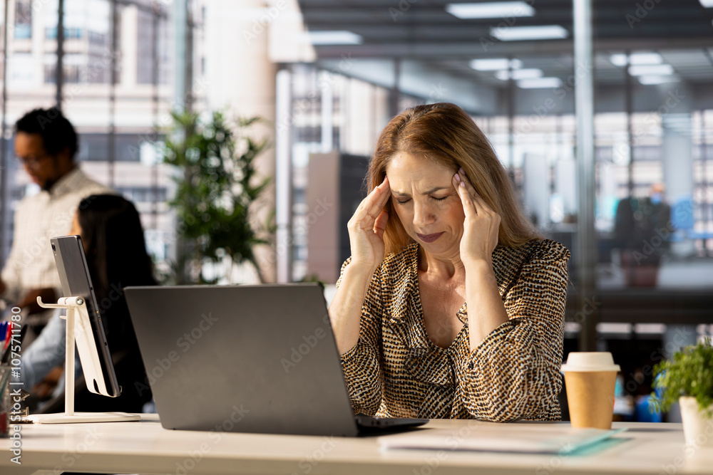 General manager sits at her laptop frustrated by the overload of business tasks. CEO dealing with fatigue and mental exhaustion after experiencing mounting pressure in the office environment. General manager sits at her laptop frustrated by the overload of business tasks. CEO dealing with fatigue and mental exhaustion after experiencing mounting pressure in the office environment.