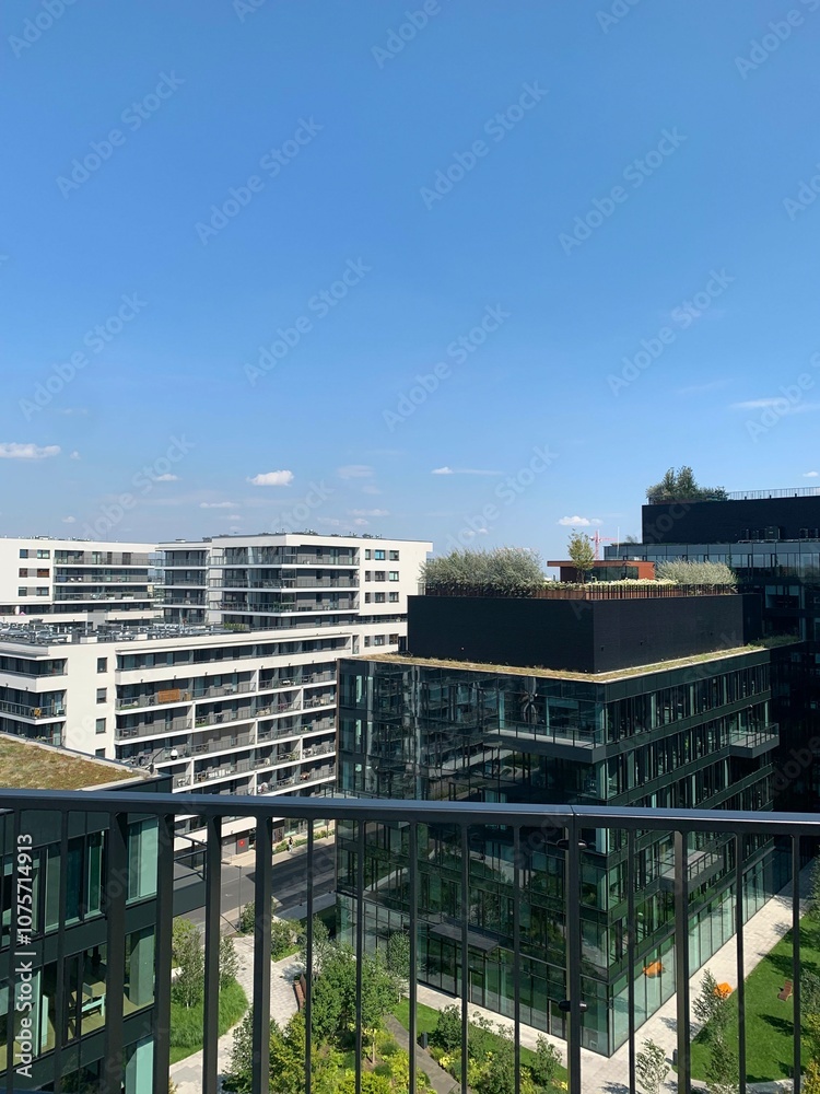 Contemporary urban buildings featuring glass facades and green rooftop gardens under a blue sky. Highlights sustainable architecture and modern city living. Ideal for themes of urban development and Contemporary urban buildings featuring glass facades and green rooftop gardens under a blue sky. Highlights sustainable architecture and modern city living. Ideal for themes of urban development and