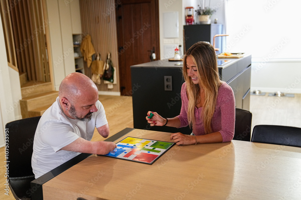 Disability man enjoying board game with friend at home Disability man enjoying board game with friend at home