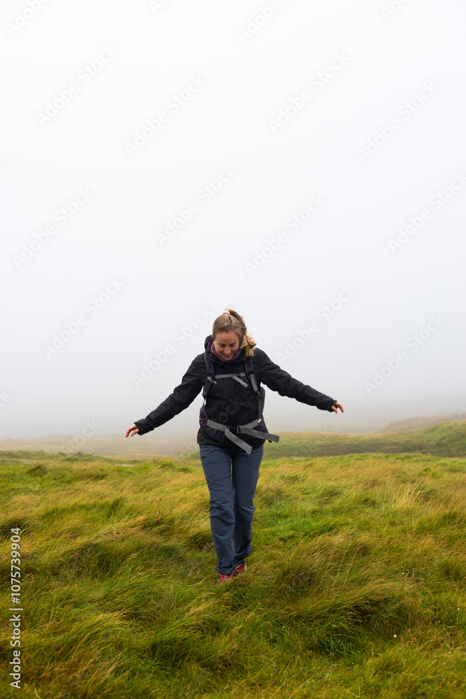 Happy hiker trekking in foggy windy Faroe Islands mountains Happy hiker trekking in foggy windy Faroe Islands mountains