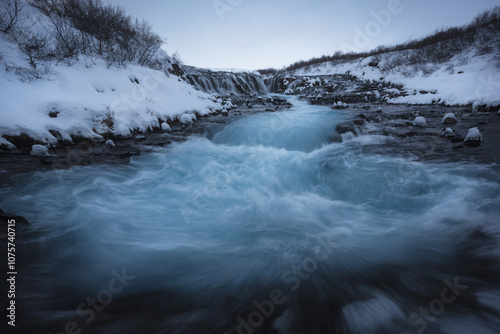 Majestic Icelandic Waterfall Amid Snowy Landscape photo