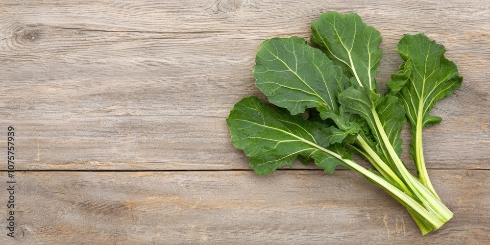 Fresh collard greens on a wooden surface, showcasing vibrant green leaves, ideal for healthy cooking and nutritious dishes. Fresh collard greens on a wooden surface, showcasing vibrant green leaves, ideal for healthy cooking and nutritious dishes.