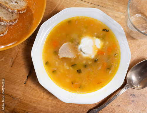 Delicious traditional rassolnik soup with sour pickles and pearl barley served in bowl photo