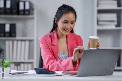 Portrait of Asian business woman holding coffee cup with work in workplace office Business documents money financial planning concept 