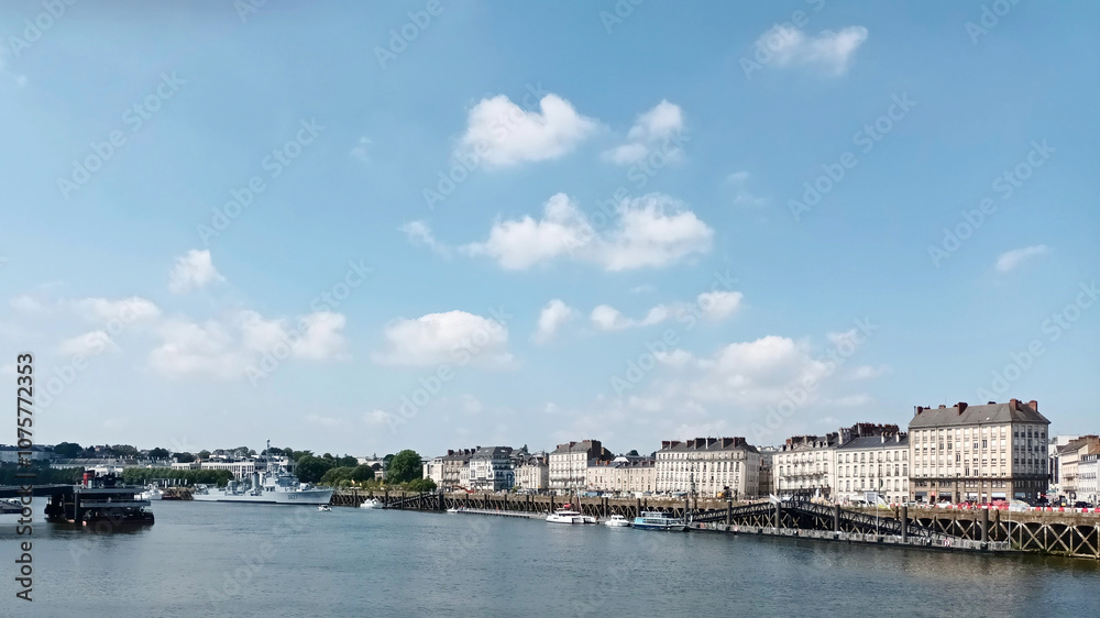 Picturesque riverside city with historic buildings against blue sky with fluffy clouds Picturesque riverside city with historic buildings against blue sky with fluffy clouds