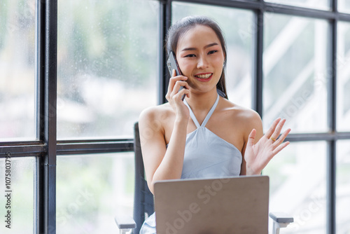 Cheerful beautiful Asian woman in the office workplace with talking on the phone business finance concept. Free Download Cheerful beautiful Asian woman in the office workplace with talking on the phone business finance concept. - GFXLoad