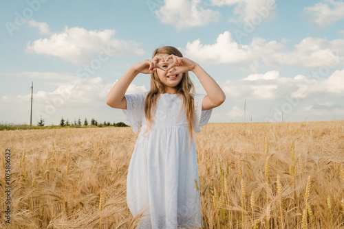 Up close portrait of happy young girl in sunny corn field.Close-up portrait of a young blonde in a golden field on a sunny summer day. Pretty blonde posing against the background of nature. Summer .