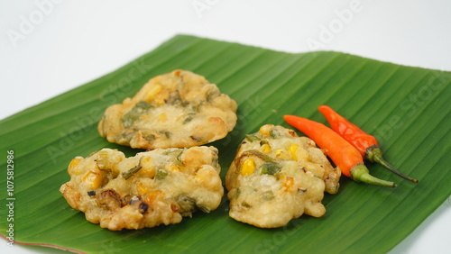 Bakwan jagung or bakwan, a traditional Indonesian snack made from flour dough mixed with vegetables and corn, served on a banana leaf. photo