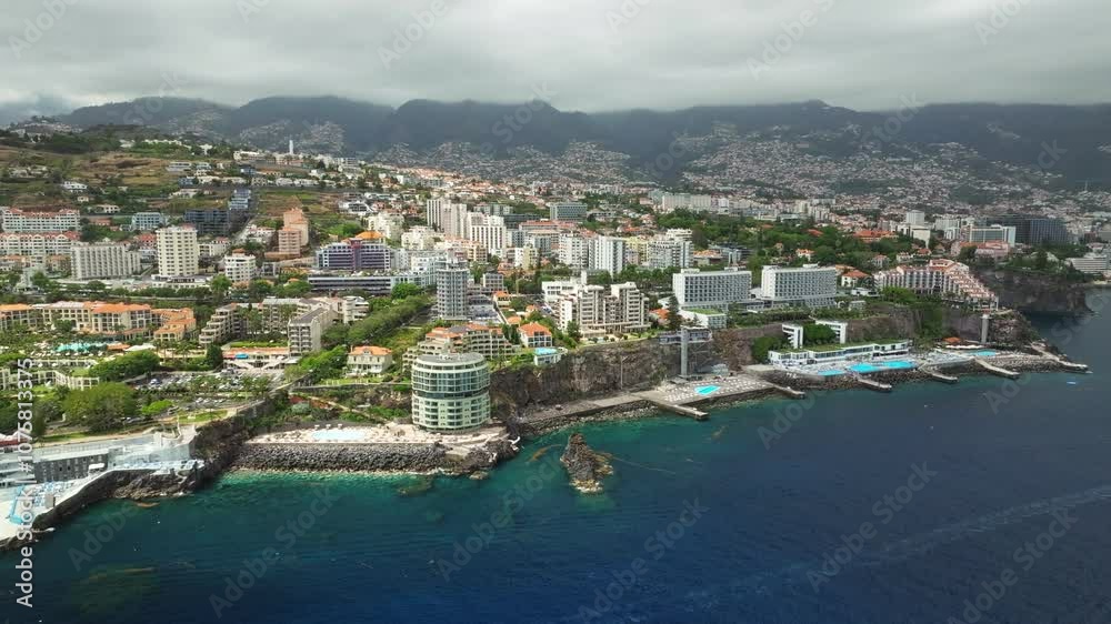 Aerial drone view of Funchal city with hotels resorts and swimming pool along the coast of Atlantic ocean. Funchal, Madeira, Portugal. Slide trucking shot Aerial drone view of Funchal city with hotels resorts and swimming pool along the coast of Atlantic ocean. Funchal, Madeira, Portugal. Slide trucking shot