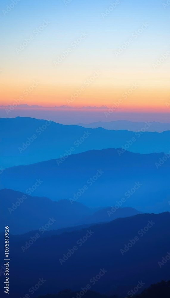 mountains are silhouetted against a blue and orange sky at sunset mountains are silhouetted against a blue and orange sky at sunset