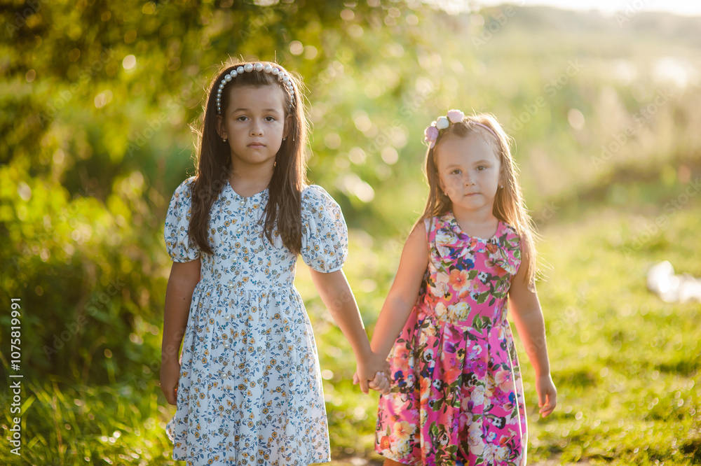 Dear native sisters are smiling.Little children, holding hands, play on their day off.Holding each other's hands, friendship. Dear native sisters are smiling.Little children, holding hands, play on their day off.Holding each other's hands, friendship.