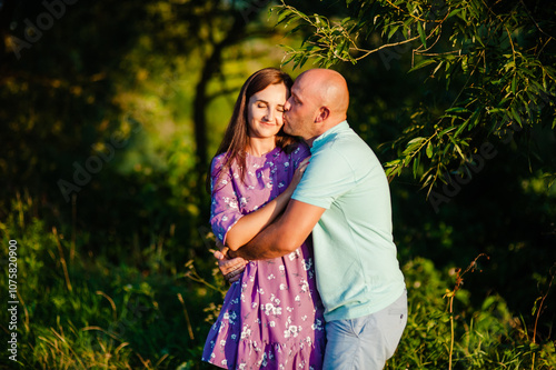 A romantic wedding couple outdoors in summer.A young married couple smiling in nature