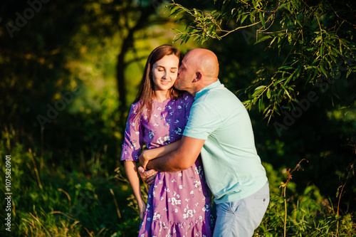 A romantic wedding couple outdoors in summer.A young married couple smiling in nature