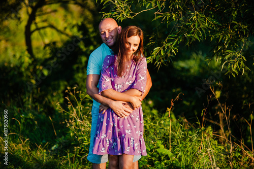 Bright summer sunlight filters through the trees, creating a warm atmosphere.This stock photo is perfect for lifestyle, family, and relationship concepts.