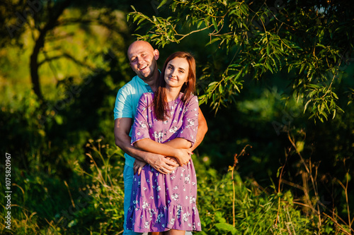 Bright summer sunlight filters through the trees, creating a warm atmosphere.This stock photo is perfect for lifestyle, family, and relationship concepts.