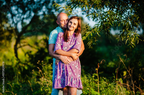 Bright summer sunlight filters through the trees, creating a warm atmosphere.This stock photo is perfect for lifestyle, family, and relationship concepts.