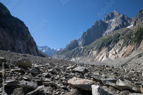 The glacial stream on the glacier Mer de Glace with the Aiguiles Towers and Garand Jorasses in the background. photo