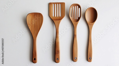 42.A set of bamboo kitchen utensils, including a spatula, spoon, and slotted spoon, carefully arranged on a white surface. The fine texture of the bamboo wood is captured in detail, making the