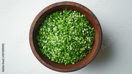 75.Overhead view of a wooden bowl filled with finely chopped spring onions, isolated on a white background. The chopped green onions are evenly spread within the bowl, their vivid color standing out