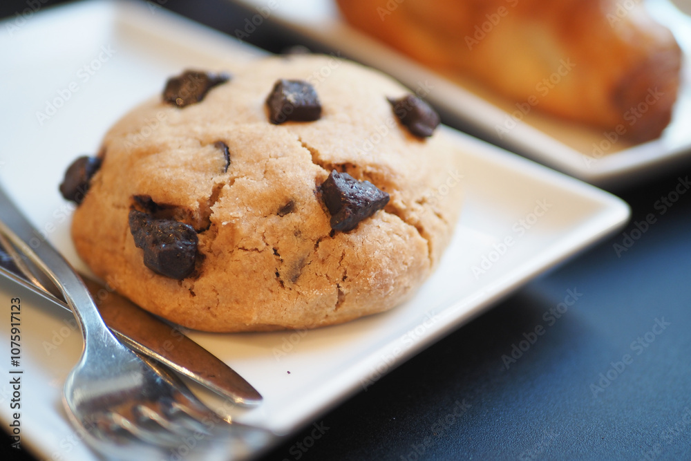 A Freshly Baked Chocolate Chip Cookie that is Perfectly Presented on an Elegant Plate for Enjoyment A Freshly Baked Chocolate Chip Cookie that is Perfectly Presented on an Elegant Plate for Enjoyment