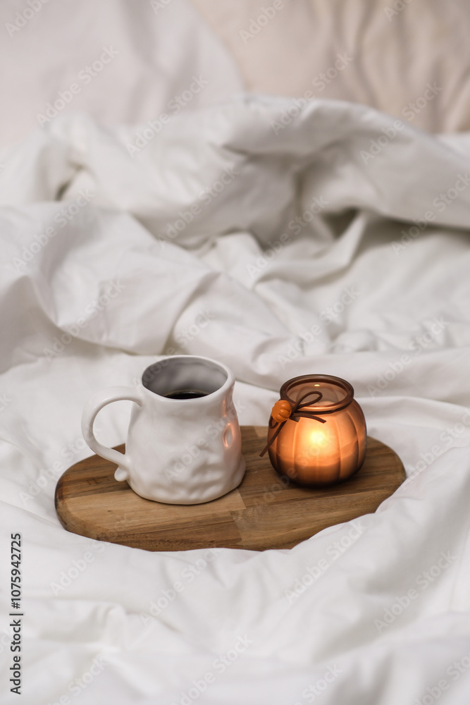 Wooden tray with coffee and interior decor on the bed with white linen Wooden tray with coffee and interior decor on the bed with white linen