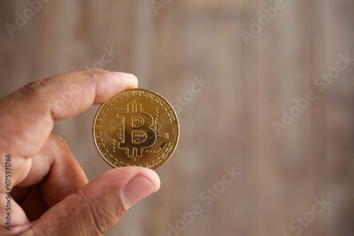 Close up hand holding bitcoin on old wood floor