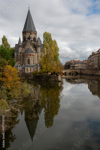 Le temple protestant de Metz , avec la Moselle en premier plan et des couleurs d'automne sur les arbres et la végétation