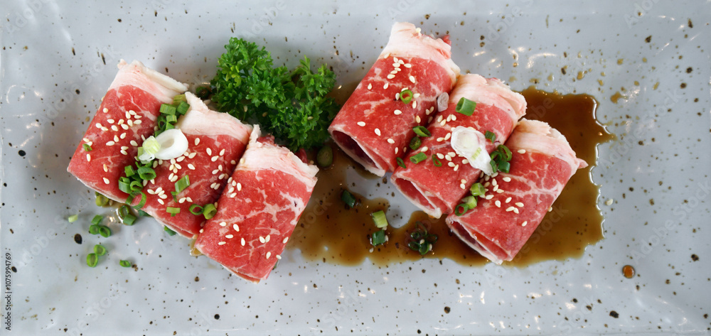Premium kagoshima kurobuta pork shoulder slice served on ceramic plate with sauce and shopped scallion. Top view