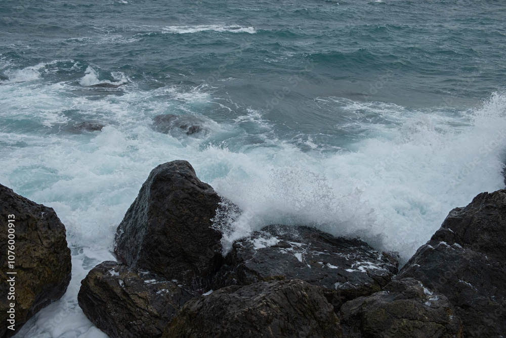 Turquoise sea stone beach, breaking waves on a cloudy spring day. Beautiful sea background. The concept of summer, vacation, travel. The purest clear sea water, large stones on the beach close-up Turquoise sea stone beach, breaking waves on a cloudy spring day. Beautiful sea background. The concept of summer, vacation, travel. The purest clear sea water, large stones on the beach close-up