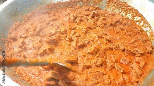 Footage of Indonesian rendang being stirred in a wok. A traditional dish from West Sumatra Province, Indonesia, which is like a combination of curry and stew. Made with beef and rich spices. photo