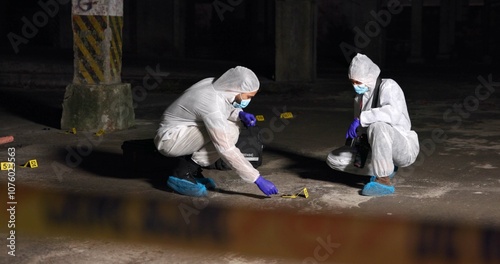 Crime scene, team or forensics at night with swab, evidence or DNA sample clue in abandoned warehouse. CSI people, hazmat suit or investigation in spotlight for legal service, inspection or pathology photo