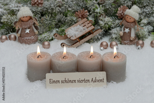 Vierter Advent: Dekoration mit vier grauen Adventskerzen und Weihnachtsschmuck im Schnee.	 photo