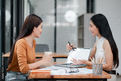 Two women discussing business strategies in a modern office setting  showcasing teamwork and collaboration.