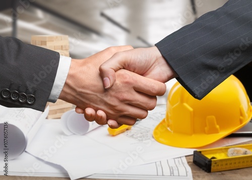 construction worker with contractor shaking hands in renovation site.