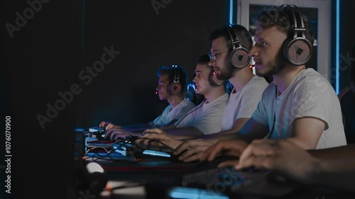 Professional gamers are playing computer game on PC at cyber club. Cyber team is using professional gaming mouse and keyboard. Pro team is playing brand name video game in Esports event at LAN cafe photo