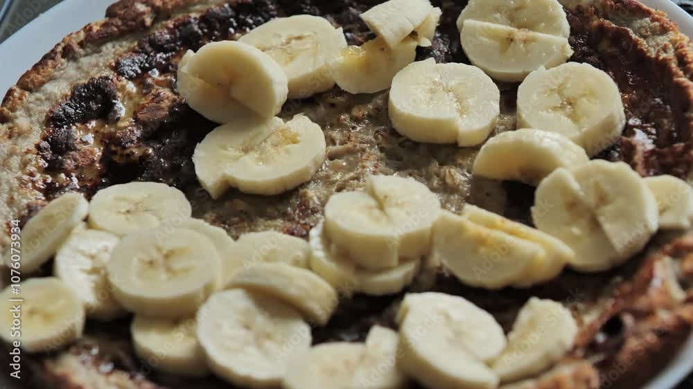 Close-up of healthy oat pancake topped with sliced bananas and drizzled honey Close-up of healthy oat pancake topped with sliced bananas and drizzled honey